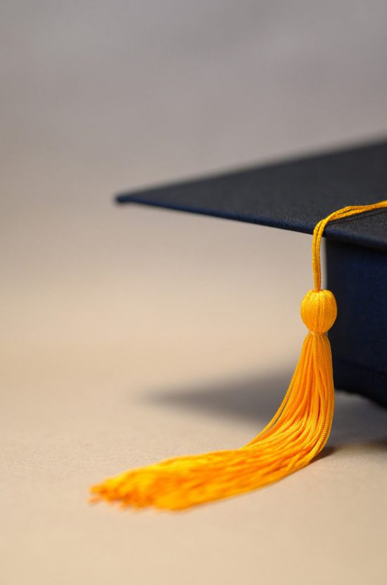black-graduation-hat-placed-brown-paper